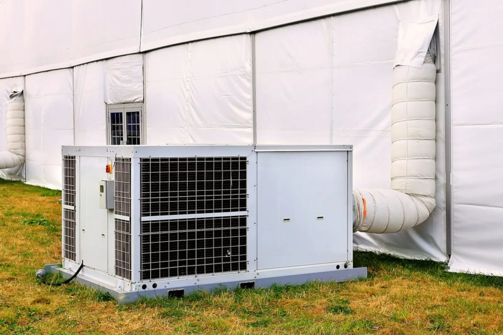 Mobile Klimaanlage mit Luftschlauch an einem Veranstaltungszelt